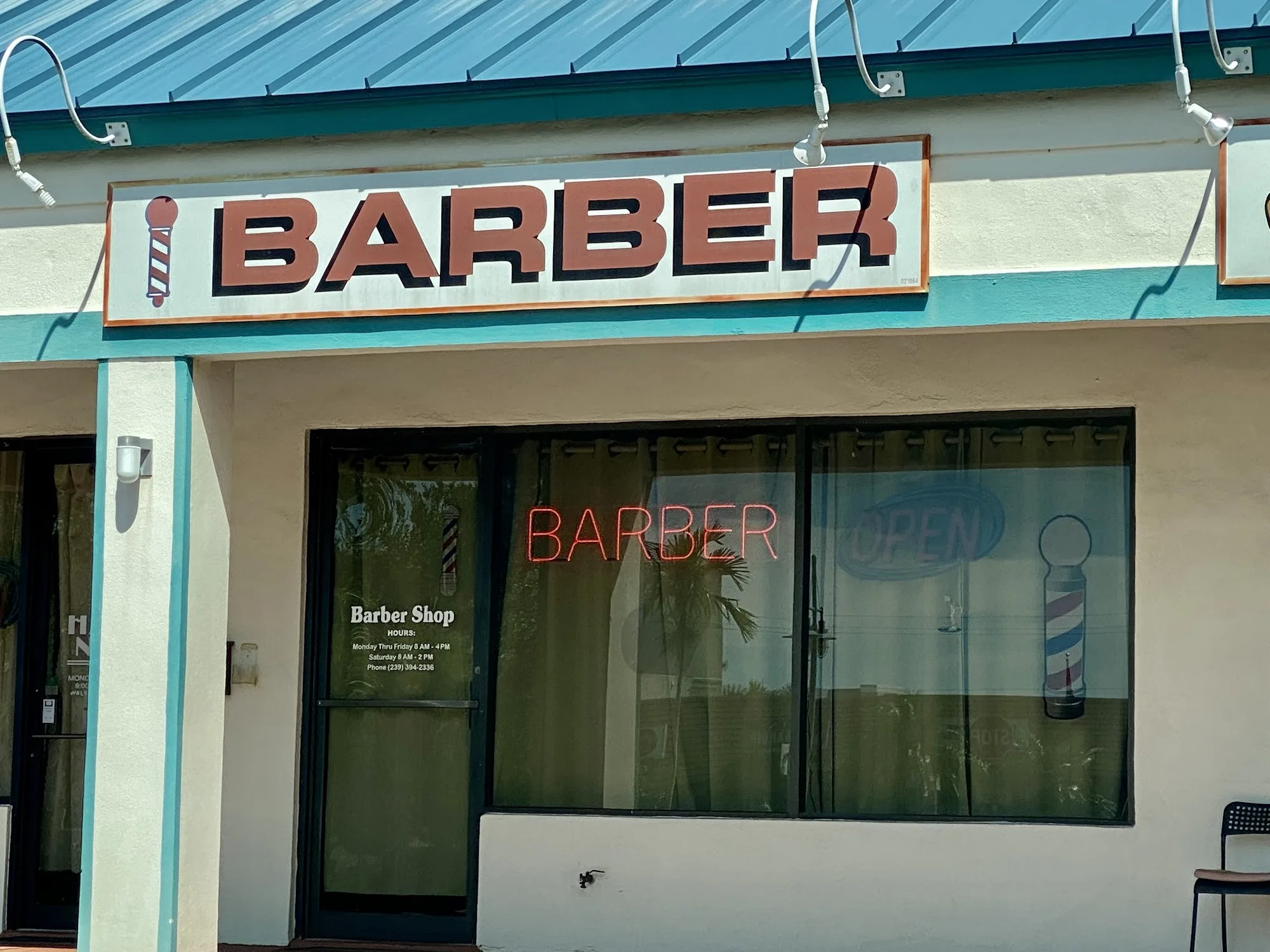 Marco Island Barber Shop storefront with its red BARBER sign under the teal awning